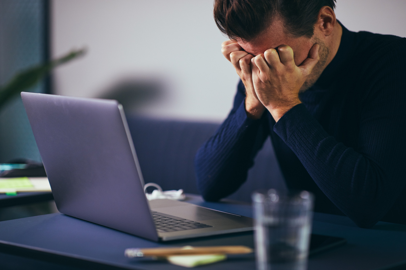 Man Looking Stressed Out at His Desk in Office